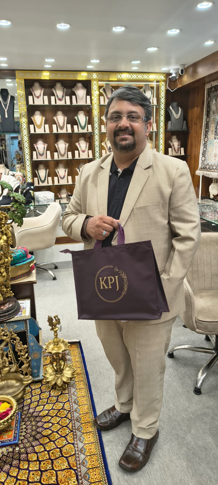 Happy customer at Krishna Pearls boutique holding a KPJ shopping bag